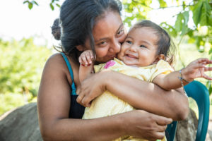 SAN VICENTE, EL SALVADOR (12/3/15)-Fani Arevelo holds her 8 month old daughter Ivania, on the site of her family's new Habitat home, which was being built as part of Habitat for Humanity El Salvador's annual “Christmas in Action” build. © Habitat for Humanity International/Ezra Millstein